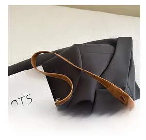 Detail view of the soft brown faux leather handle and fine stitching on a tote bag