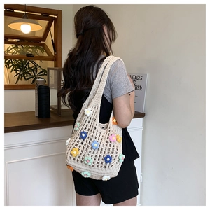 Dettaglio della borsa crochet bohémien con fiori 3D in un ambiente caldo caffè