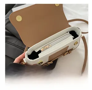 Detail view of smooth zipper pocket inside the bicolor shoulder bag with metal chain strap