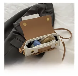 Detail view of the spacious inner compartment of the contrast color square shoulder bag