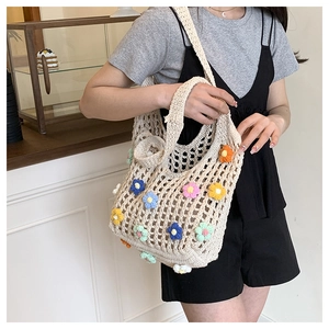 Detailed macro view of multi-color 3D crochet flower patterns on ivory knit tote bag