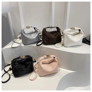 Detailed view of textured fashion handbags in silver, brown, white, black and pink