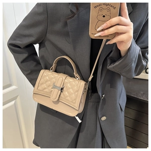 Détail du sac bandoulière beige matelassé avec fermoir argenté et poignée élégante