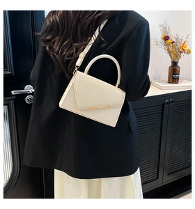 Détail du mini sac crème avec texture tissée et finitions métalliques dorées élégantes