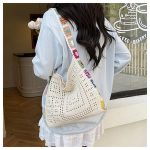 Detail of hand-crocheted cream tote bag with colorful floral pattern and woven texture