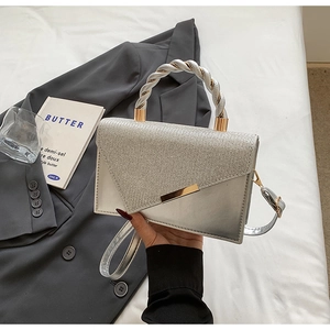 Détail du sac bandoulière argenté avec texture scintillante et poignée tressée