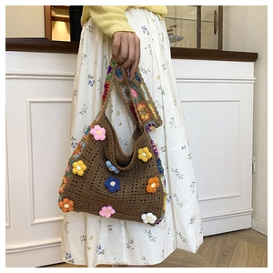 Dettaglio borsa a tracolla all'uncinetto con fiori 3D colorati e cinturino intrecciato