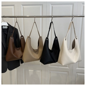 Sacs cabas en cuir marron, kaki, noir et beige suspendus sur un cintre métallique