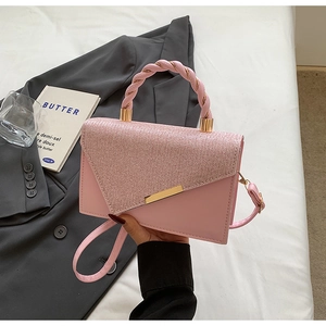 Détail du sac carré rose cerise avec rabat scintillant et poignée métallique torsadée