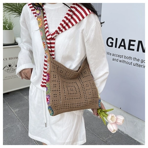 Detail of bohemian crochet hollow bag featuring colorful floral patchwork strap
