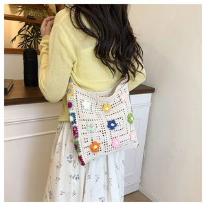 Dettaglio borsa tote all'uncinetto con fiori 3D colorati e tracolla in maglia intrecciata