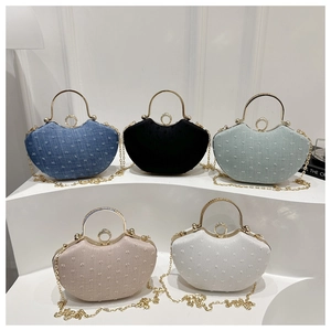 Detail of five mini evening bags with gold handles and rhinestone-encrusted round buckles