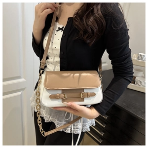 Detail of color-block crossbody bag featuring brown flap and white PU leather texture