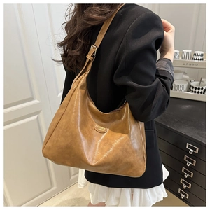 Close-up of adjustable strap and vintage brown PU leather texture on a tote bag