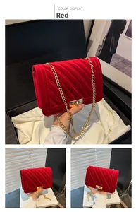 Detailed view of red quilted velvet handbag with gold chain strap in premium gift packaging