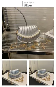 Detailed view of silver shell-shaped mini bag with pearl handle and metal chain strap