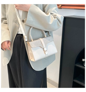 Detail view of cream white crossbody bag with silver glitter flap and metallic twist lock