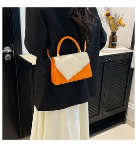 Détail d'un sac bandoulière chic orange et beige avec empiècements et boucle métallique