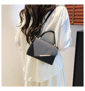Détail d'un sac bandoulière aux textures mixtes avec finitions dorées sur un mannequin