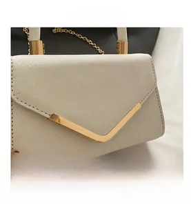 Detail of the champagne glitter fabric and gold V-shaped buckle on the luxury evening bag