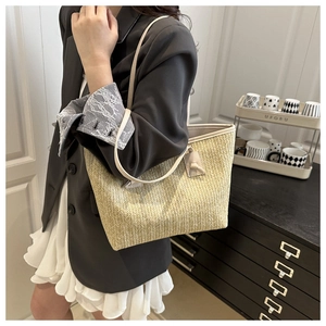 Model wearing a large beige woven straw tote bag with leather straps for daily outfit