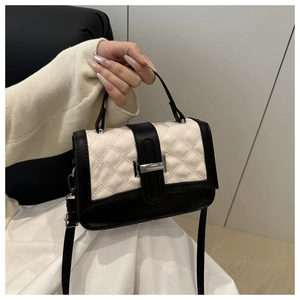 Détail du sac à bandoulière matelassé avec contraste noir et blanc et fermoir métal