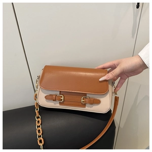 Close-up of color-block crossbody bag with resin chain and buckled strap details