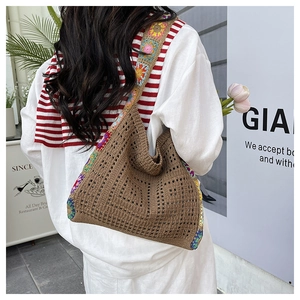 Detail of bohemian hollow knit tote with colorful crochet floral patterns on straps