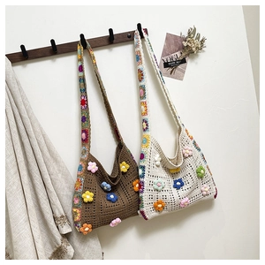 Detailed close-up of handmade crochet tote bag with 3D floral accents and colorful granny squares