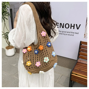 Dettaglio della borsa a tracolla in maglia intrecciata con fiori 3D colorati