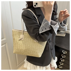 Detail of handwoven straw tote with elegant V-pattern and slim leather handles
