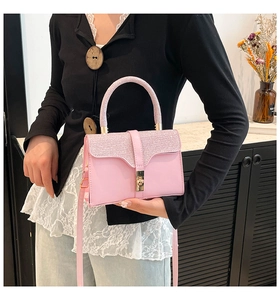 Close-up of pink faux leather bag featuring sequined flap and gold metal clasp lock