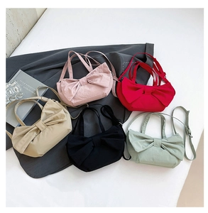 Flat lay of mini bow handbags in pink, red, beige, black, and light green colors