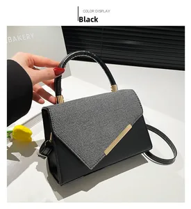 Détail du sac à main noir avec rabat en tweed et finitions métalliques dorées chic