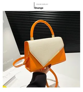 Détail du sac à main bicolore en cuir orange avec rabat en texture tissée beige