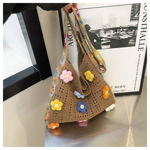Detail of handmade brown crochet tote bag with colorful 3D floral pattern and vintage straps