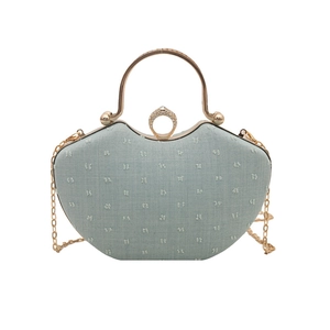 Mini heart-shaped crossbody bag in light cyan fabric with gold handle and chain strap