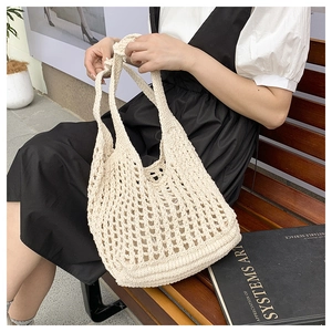 Close-up of handmade cream crochet tote bag featuring intricate hollow woven texture