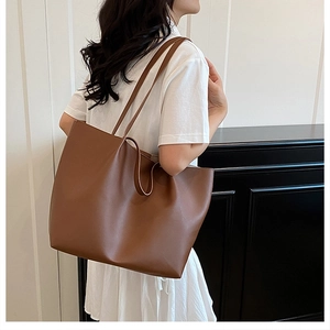 Minimalist brown leather tote bag styled on model in modern minimalist interior