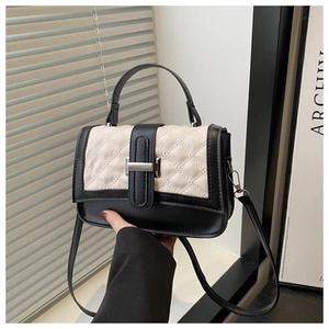 Détail du sac à main bicolore noir et blanc avec surpiqûres en losanges et fermoir métallique