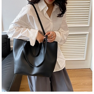 Minimalist black matte leather tote bag shown in a professional commuting style scene