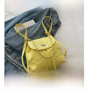 Detailansicht des gelben Rucksacks mit Herzsteppung, Kette und Handy als Größenvergleich