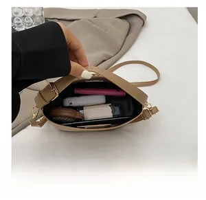 Interior view of the beige crossbody bag showing space for cosmetics and phone
