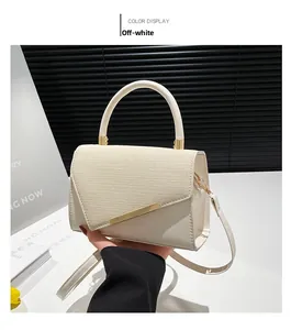 Détail du sac beige à rabat texturé avec poignée métallique et bandoulière amovible