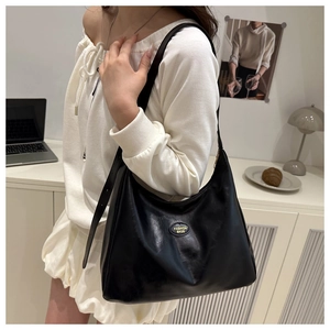 Detail of black soft leather tote bag with Fashion Bags metal logo for daily commute