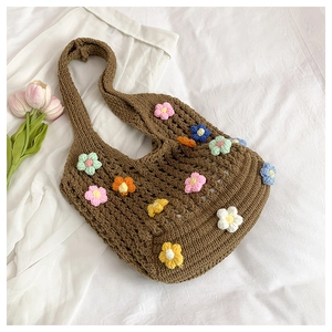 Macro shot of dark brown hand-woven tote bag with colorful 3D crochet flower details