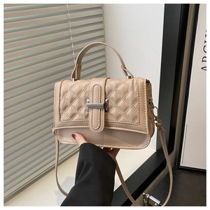 Détail du sac beige en cuir matelassé avec boucle en H argentée et poignée élégante