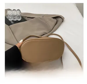 Detail view of khaki PU leather oval crossbody bag showing durable bottom stitching