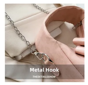Close-up of high-quality silver metal hooks and chain links on a pink crossbody bag