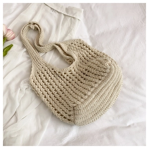 Macro shot of off-white knit crochet tote bag showing hollow mesh and thick woven texture